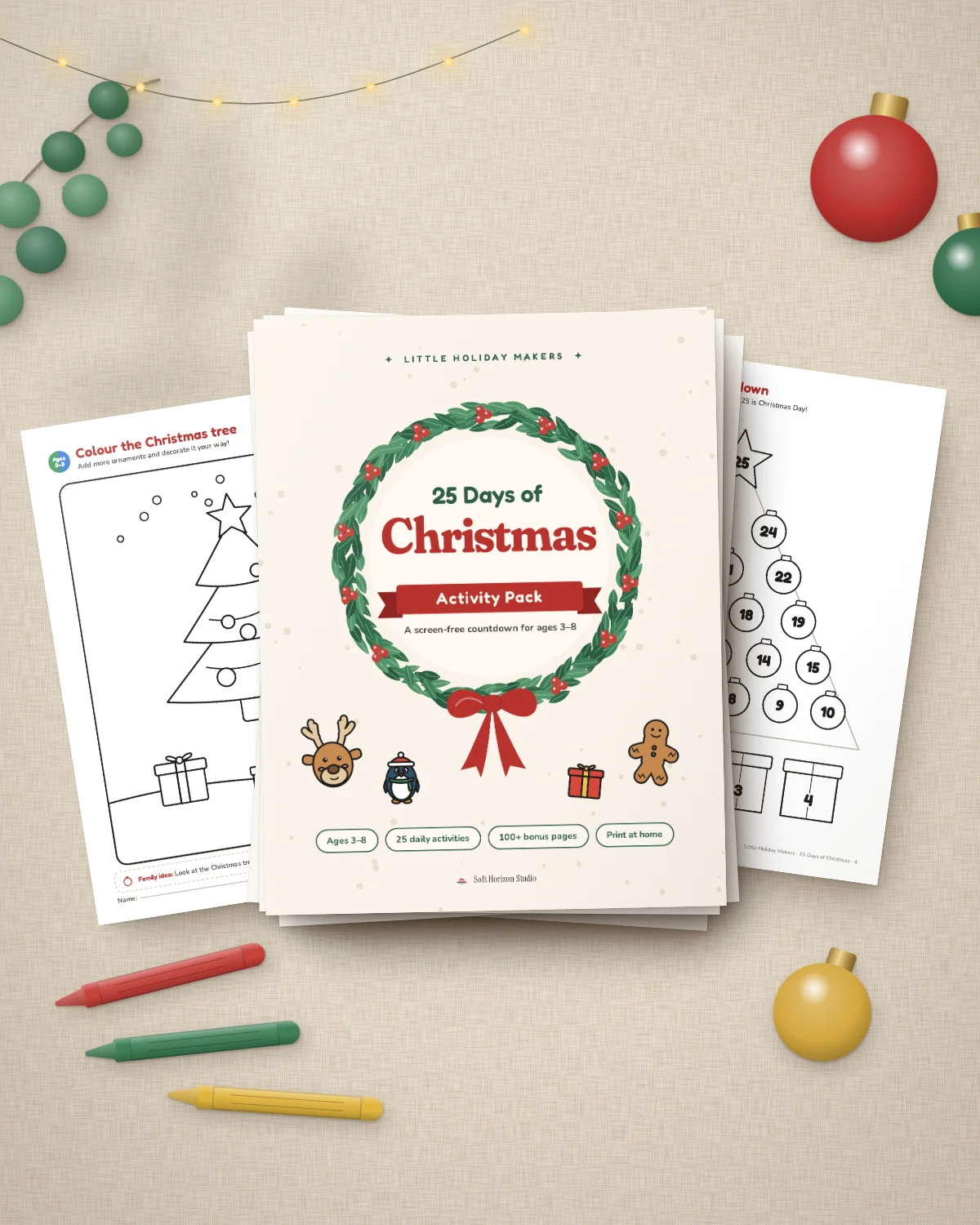 The 25 Days of Christmas pack printed on a table with crayons, ornaments and fairy lights